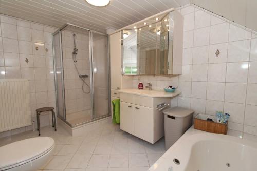 a bathroom with a tub and a toilet and a shower at Ferienhaus am Ostfrieslandwanderweg, 15177 in Leer