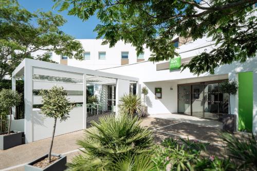 a white building with plants in front of it at ibis Styles Les Sables Olonne in Les Sables-dʼOlonne