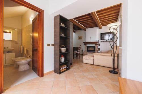 a bathroom with a toilet and a living room at Casa con posto auto coperto e ampio giardino in Lucignano