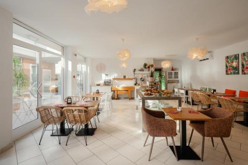 um restaurante com mesas e cadeiras e uma cozinha em I Cinque Pini em Follonica