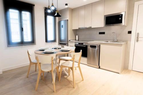 eine Küche mit einem Tisch und Stühlen im Zimmer in der Unterkunft Apartamento Capri Living Suites en Castellon in Castellón de la Plana