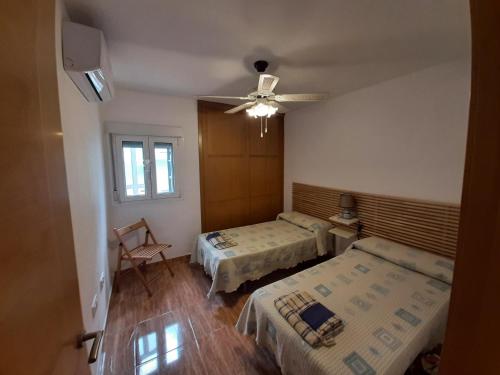 1 dormitorio con 2 camas y ventilador de techo en Apartamento Las Gaviotas en Cabo de Gata
