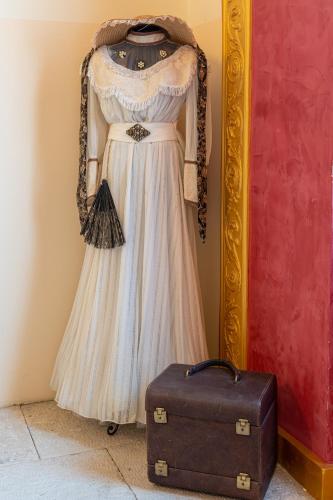a dress hanging on a wall next to a suitcase at Hotel Stara šola - Oleander Resort in Izola