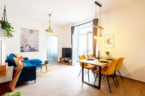 uma sala de estar com uma mesa e um sofá azul em FeelgooD Apartments DELUXE Zwickau CityCenter mit TG-Stellplatz, Netflix und Waipu-TV em Zwickau