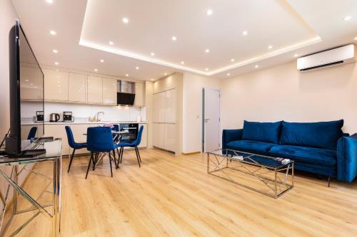 uma sala de estar com um sofá azul e uma cozinha em Cityscape Retreat 1BD Flat in the Heart of Plovdiv em Plovdiv