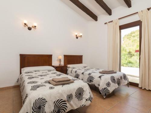 two beds in a room with a window at Villa Tauler in Son Serra de Marina
