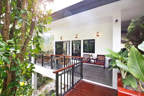 a porch of a house with benches and trees at 2 Bays Villa in Thong Nai Pan Yai