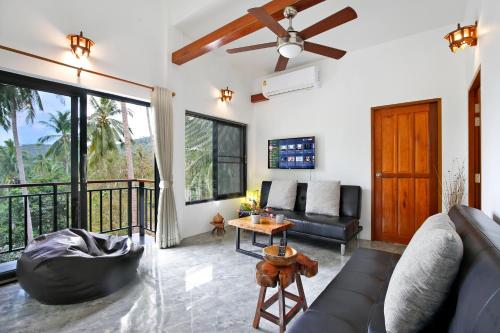 a living room with a couch and a ceiling fan at 2 Bays Villa in Thong Nai Pan Yai