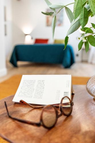 a pair of glasses sitting on a table with a book at Auberge des braconniers in Ampus