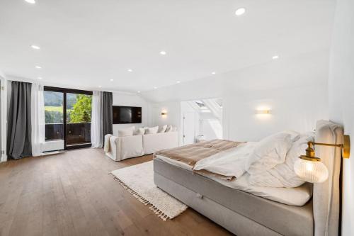 a white bedroom with a large bed and a couch at Villa Chou Chou in Steinhaus am Semmering