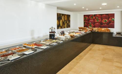 a buffet line with many different types of food at Hotel Tres Torres in Santa Eularia des Riu