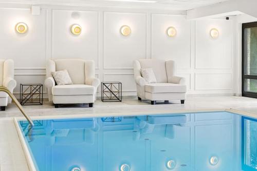 a room with two chairs and a swimming pool at Villa Chou Chou in Steinhaus am Semmering