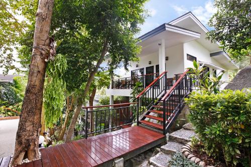a house with a red staircase in front of a house at 2 Bays Villa in Thong Nai Pan Yai