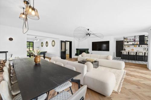 a living room with a black table and white furniture at Villa Chou Chou in Steinhaus am Semmering