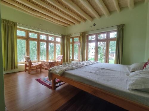 1 dormitorio con 1 cama grande en una habitación con ventanas en Streamlet homestay, en Leh
