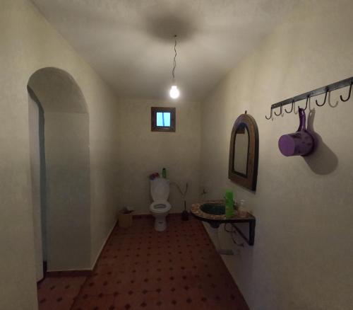 La salle de bains est pourvue de toilettes, d'un lavabo et d'un miroir. dans l'établissement Sahara Luxury Camp M'hamid, à Mhamid