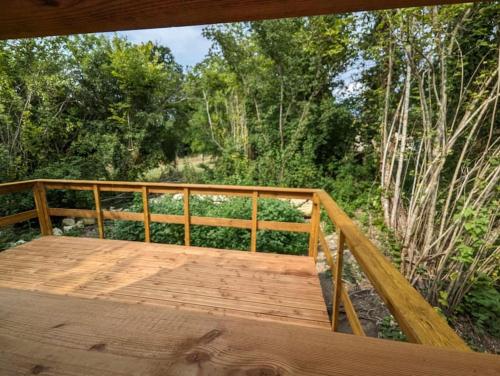 une terrasse en bois avec vue sur les bois dans l'établissement Gîte le noisetier 3-6 personnes, à Blésignac