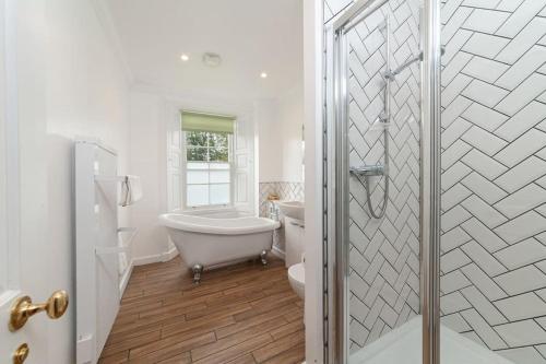 uma casa de banho com uma banheira, um WC e um lavatório. em Hexham House Penthouse Apartment Seven em Hexham