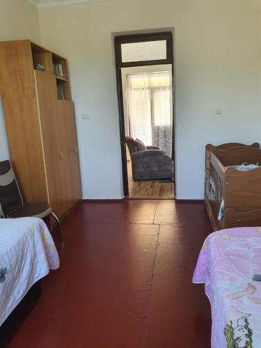 a room with two beds and a door with a couch at Гостевой дом у Эмзара in Batumi