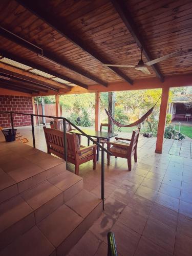 a patio with two chairs and a table and a hammock at Casa confortable hasta 7 personas in Posadas