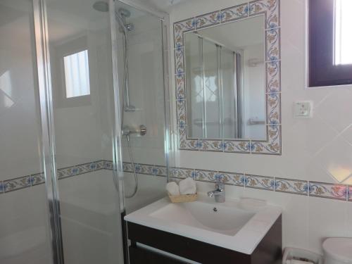 a bathroom with a shower and a sink and a mirror at Villa El Alcazar in Carvoeiro
