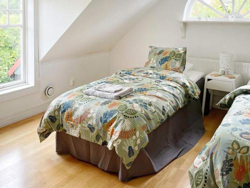a bedroom with a bed with a colorful comforter at Holiday home RONNEBY X in Ronneby