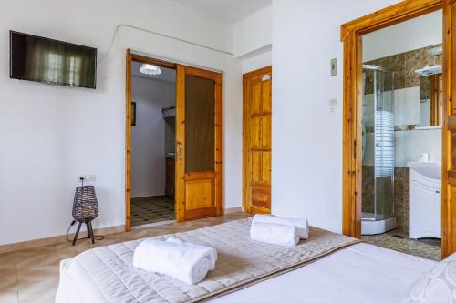 a bedroom with a large bed and a bathroom at Panagou Studios in Skopelos Town