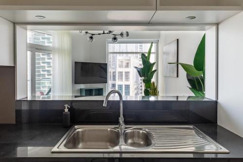 a kitchen with a sink and a mirror at Frank Porter - The Lofts East in Dubai