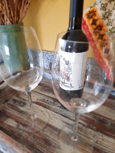 two wine glasses sitting on a table with a bottle of wine at Pacha Home By A.M.A in San Carlos de Bariloche