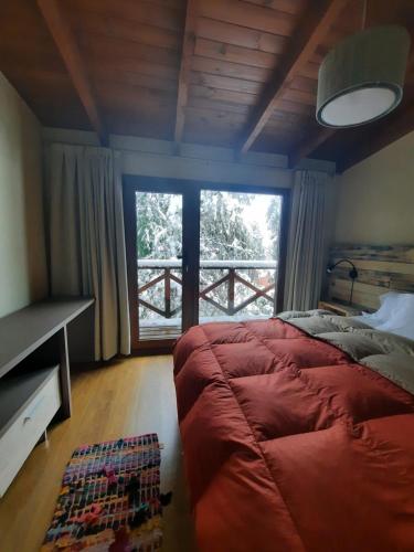 a bedroom with a large bed and a large window at Pacha Home By A.M.A in San Carlos de Bariloche