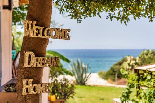 a sign on a tree that reads welcome dream house at Malsova-Home in Kotrónion