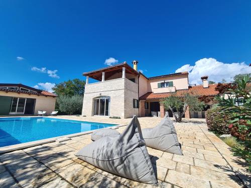 a home with a swimming pool and a house at Spacious villa with pool, indoor jacuzzi and sauna near Poreč in Višnjan