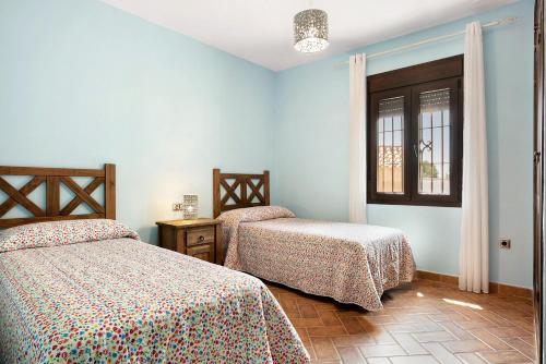 a bedroom with two beds and a window at Casa Sonia y Nuria in Roche