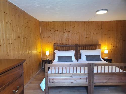 a bedroom with a large bed with wooden walls at Margherita Apartment by Quokka 360 - apartment in wooden house in the village of Osco in Faido