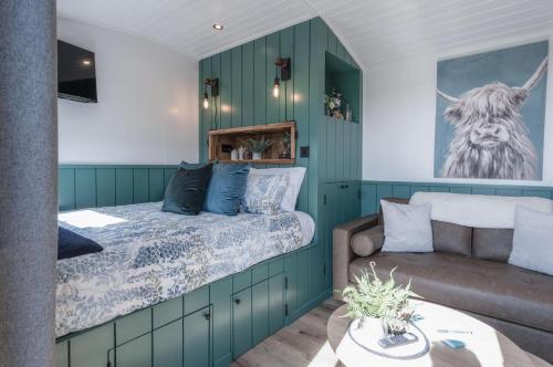 a bedroom with a bed and a couch at Willows Rest - 1 Bed Shepherds Hut - Pentlepoir in Saundersfoot