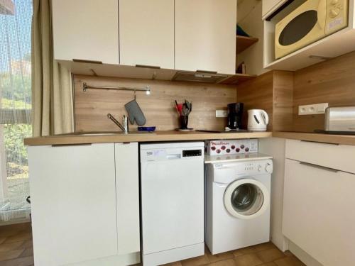 une cuisine avec une machine à laver et un évier dans l'établissement Studio cabine 4 pers avec terrasse, parking et accès plage - FR-1-226B-167, à Cavalaire-sur-Mer