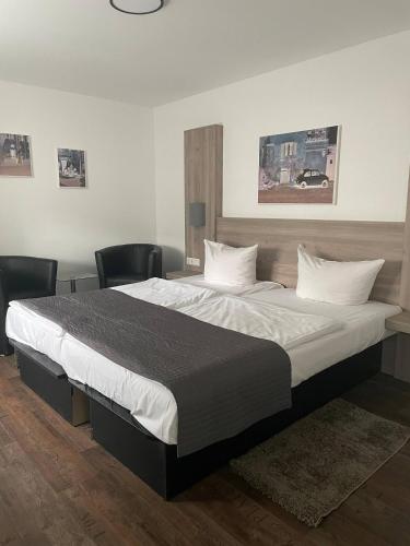 a bedroom with a large bed with two chairs at Casalino in Wachtendonk