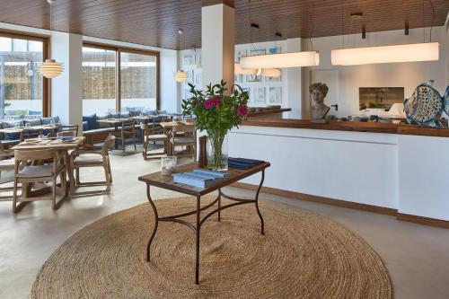 a living room with a table with flowers on it at Hotel Tres Torres in Santa Eularia des Riu