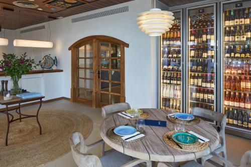 a dining room with a table and chairs and wine bottles at Hotel Tres Torres in Santa Eularia des Riu