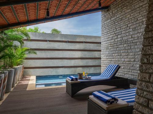 a patio with a table and chairs next to a swimming pool at Angsana Oasis Spa & Resort in Yelahanka