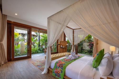 a bedroom with a large bed with a canopy at Villa Lembah Damai by Pramana Villas in Gianyar