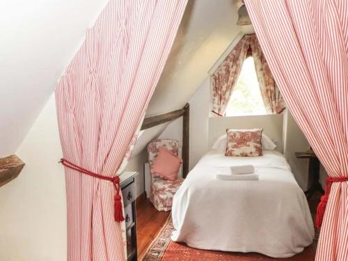 a bedroom with a bed and curtains in a attic at The Hen House in Bridgend