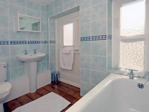ブリジェンドにあるThe Hen Houseの浴槽、洗面台、トイレを備えたバスルーム