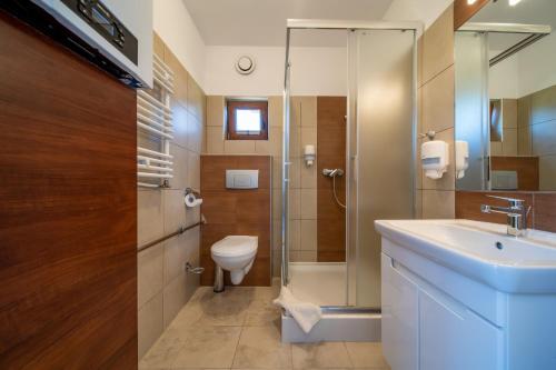 a bathroom with a toilet and a sink and a shower at Apartamenty Gromada Międzyzdroje in Międzyzdroje