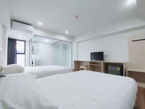 Ban Bang Toei (1)的住宿－Lucky Elephant Hotel，一间白色卧室,配有两张床和电视
