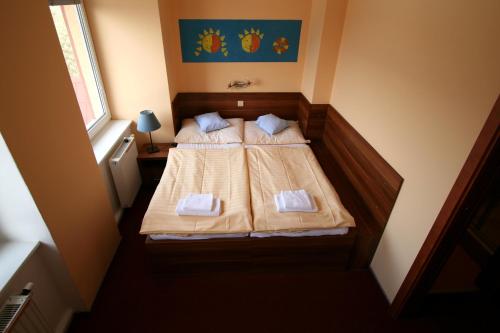 a small bedroom with a bed with two white pillows at Hotel Sluníčko in Ostravice
