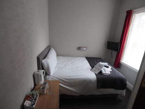 a hotel room with a bed and a table at Richmond House in Southport