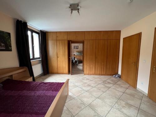 ein leeres Zimmer mit einem Bett und einem Flur in der Unterkunft Gemütliche 2-Zimmer-Privat-Unterkunft mit Kamin in EFH in Spiegelberg