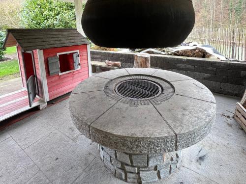 una mesa de piedra y una casa de pájaros en un patio en Gemütliche 2-Zimmer-Privat-Unterkunft mit Kamin in EFH, en Spiegelberg