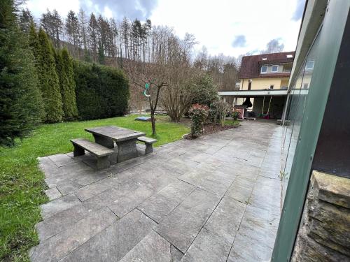 un patio de piedra con una mesa de picnic en un patio en Gemütliche 2-Zimmer-Privat-Unterkunft mit Kamin in EFH, en Spiegelberg